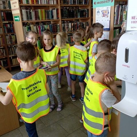 Powiększ obraz: Przedszkolaki oglądają zbiory biblioteki w dziale dziecięcym