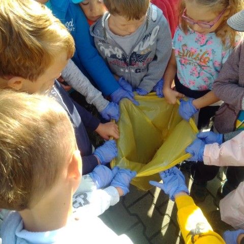 Powiększ obraz: Dzieci trzymają żółty worek na plastik