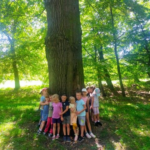 Powiększ obraz: Dzieci przytulają się do drzewa