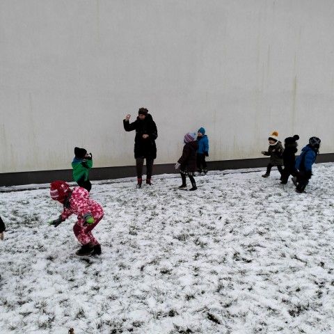 Powiększ obraz: Przedszkolaki wspólnie z Panią bawią się na śniegu