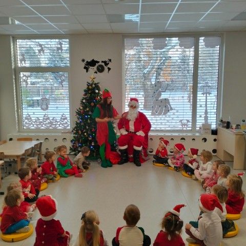 Powiększ obraz: Dzieci siedzą w kole i śpiewają piosenkę dla Mikołaj