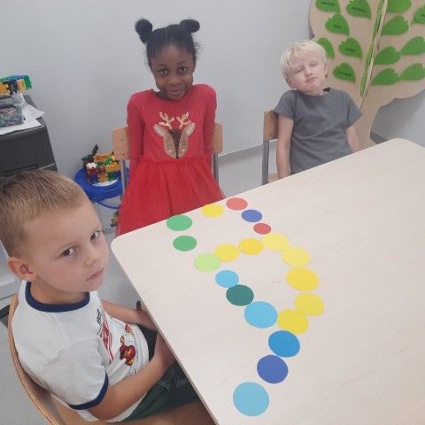Powiększ obraz: Dzieci układają kształt z kolorowych kropek