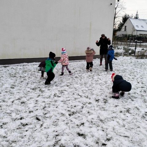 Powiększ obraz: Dzieci wspólnie z Panią rzucają się śnieżkami