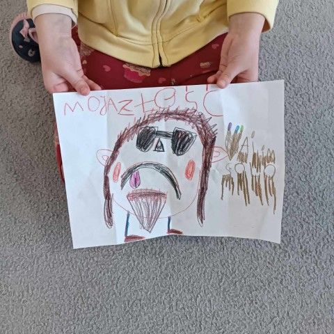 Powiększ obraz: Dziewczynka trzyma rysunek przedstawiający złość