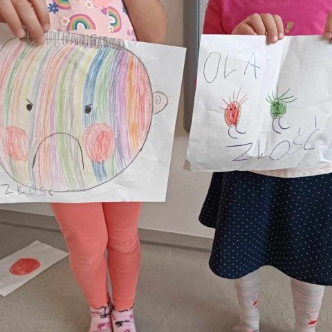 Powiększ obraz: Dwie dziewczynki stoją ze swoimi rysunkami