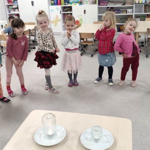 Powiększ obraz: Dzieci obserwują eksperyment świeczkowy